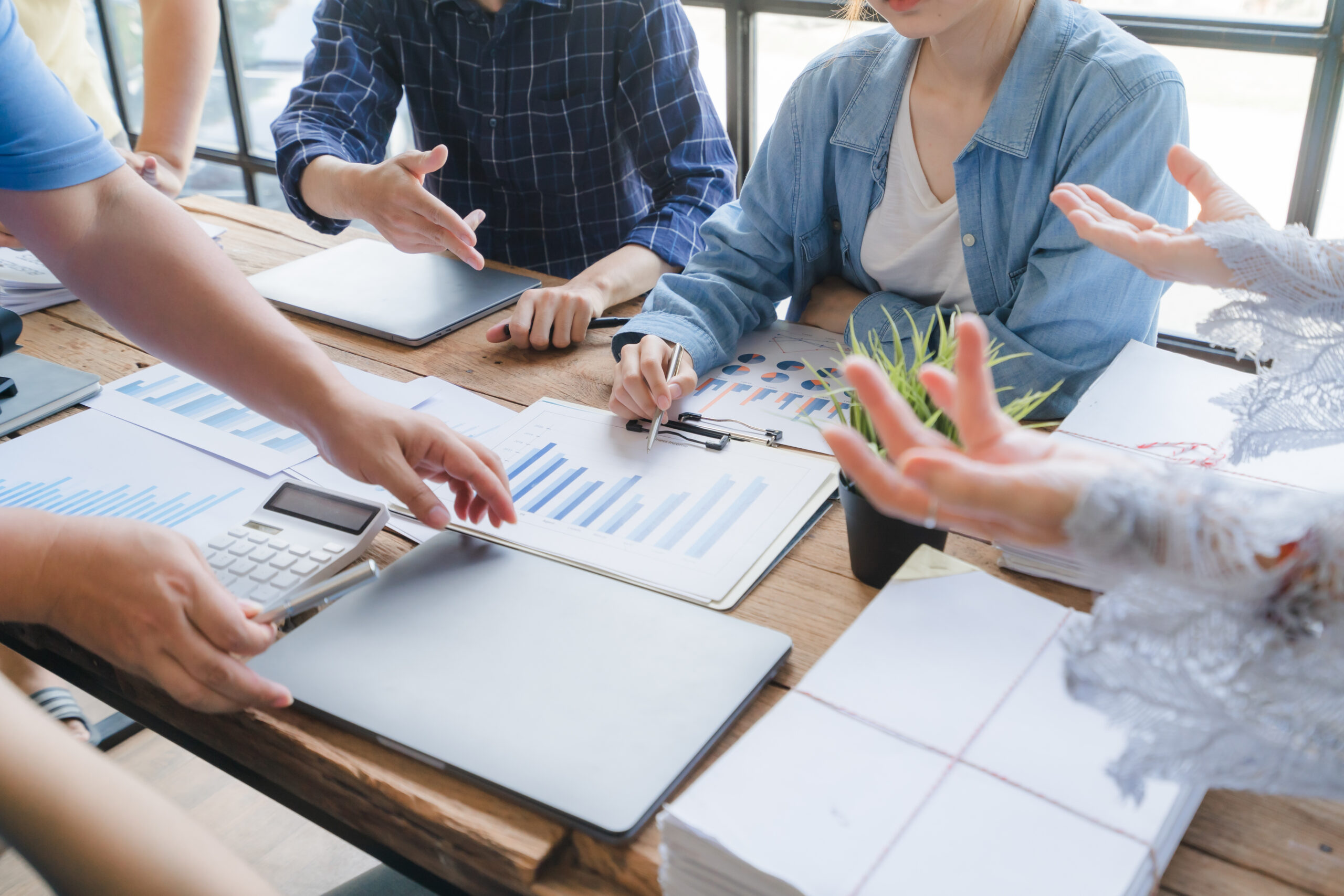 Equipe de profissionais em reunião de negócios B2B analisando dados e gráficos